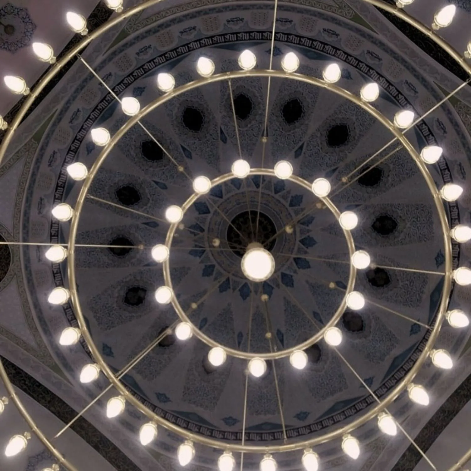 Dev halkalı Osmanlı borulu cami avizesi kubbe altından görünüm, halkalar kubbe göbeğini çerçeveliyor