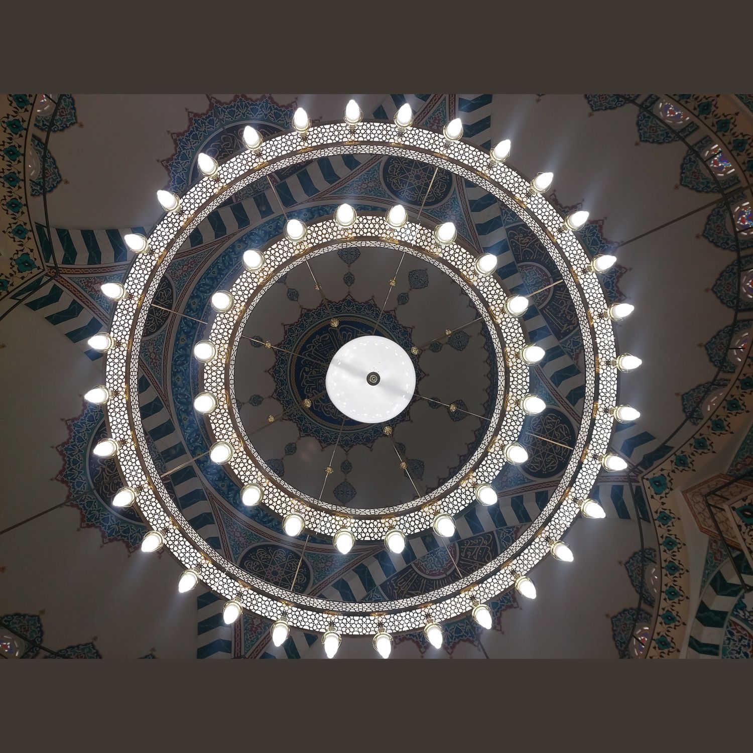 İki kademeli Medine kutulu Selçuklu cami avizesi tam alttan görünüm, halkalar kubbe göbeğini çerçevelerken
