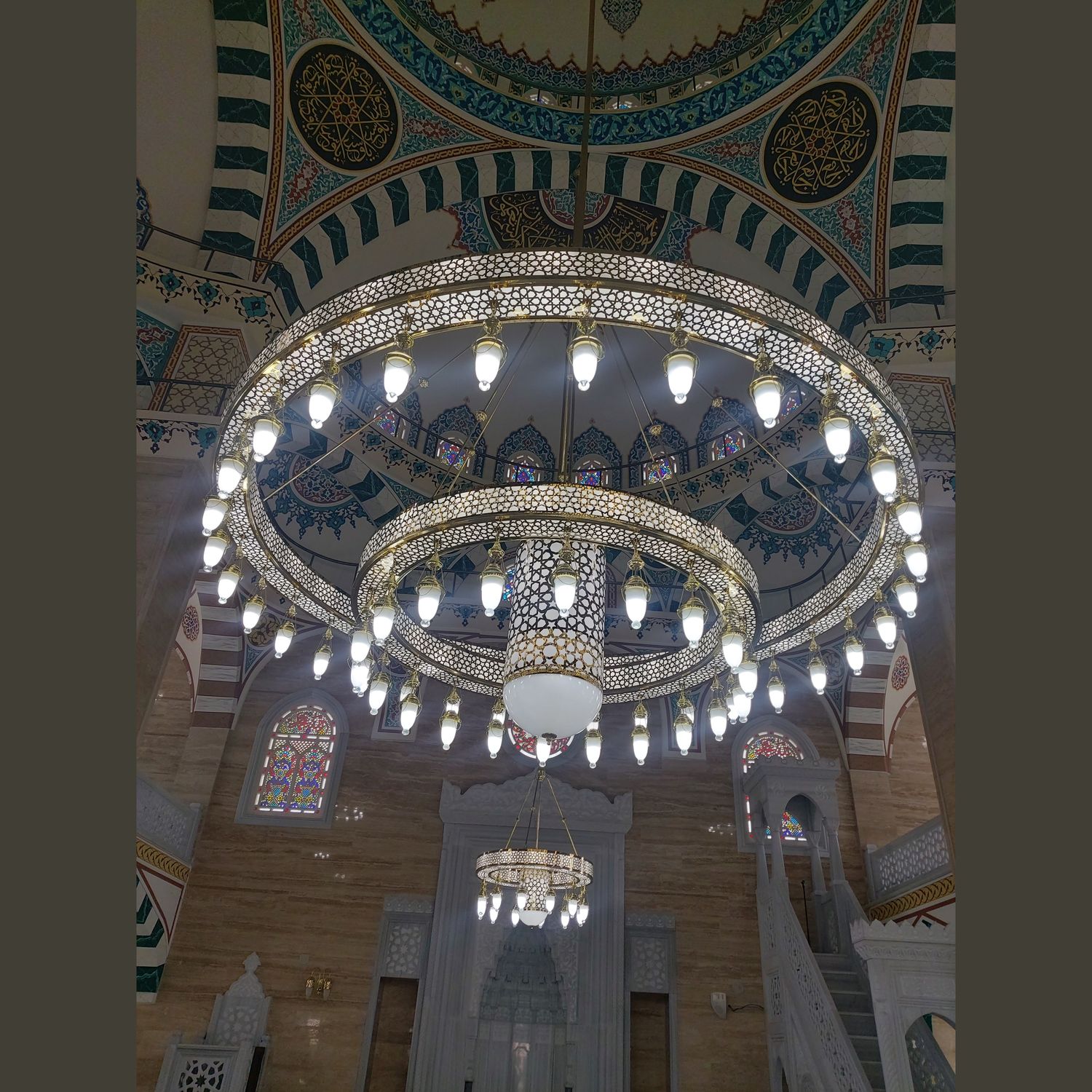 İki kademeli Medine kutulu Selçuklu cami avizesi mihrap yönünden görünüm, kalem işli kubbe önünde yanarken