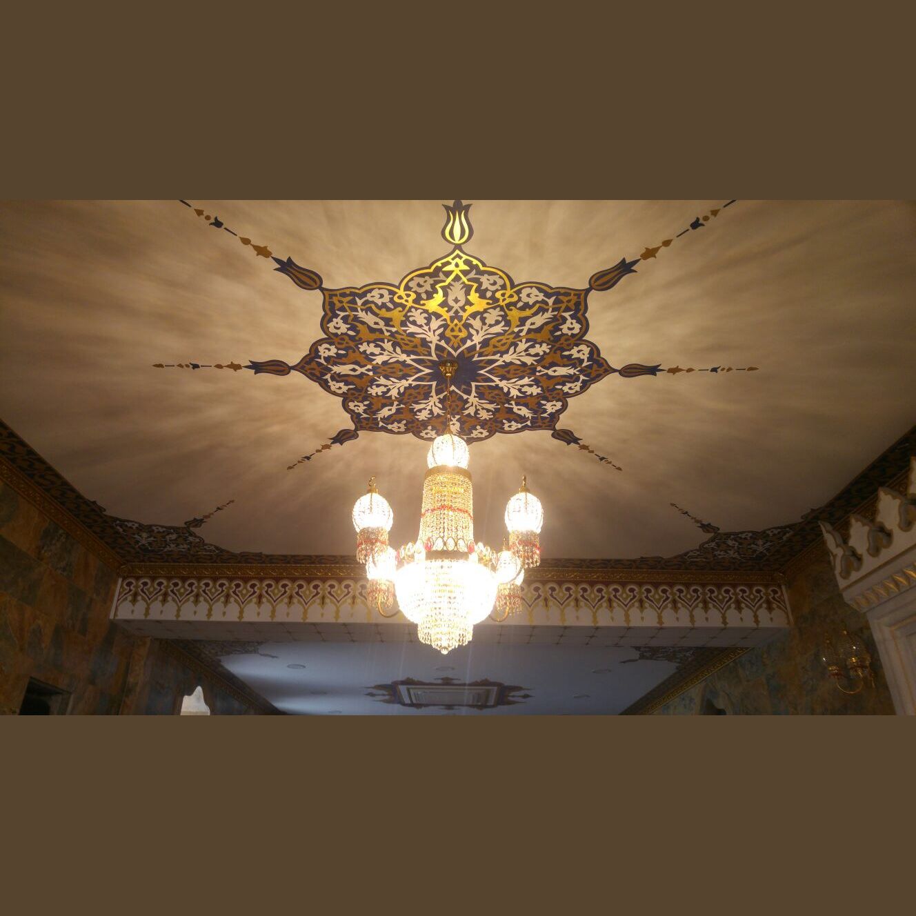 Kandilli kristal cami avizesinin işlemeli tavan göbeği ile birlikte görünümü