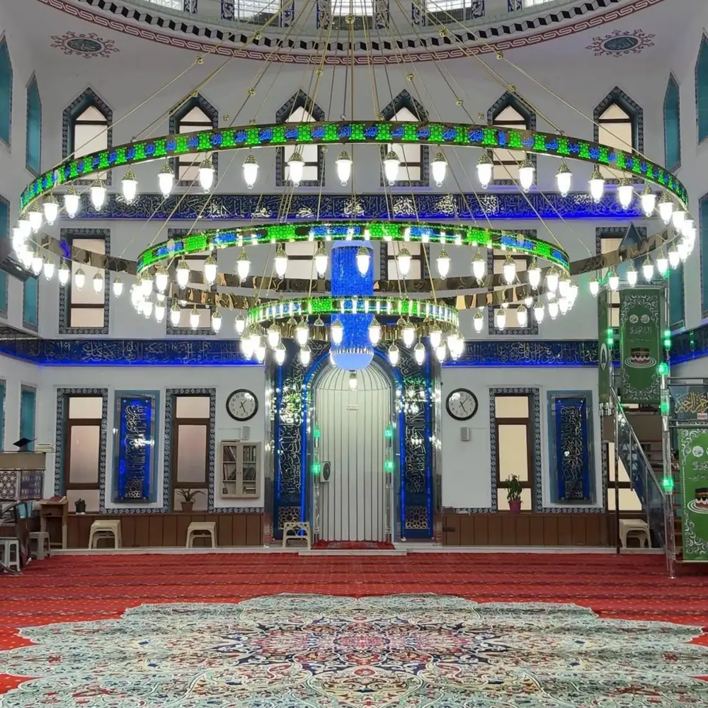 Mavi göbekli Esmaül Hüsnalı ledli cami avizesi mihrap önünde, caminin ana hacminde yanarken