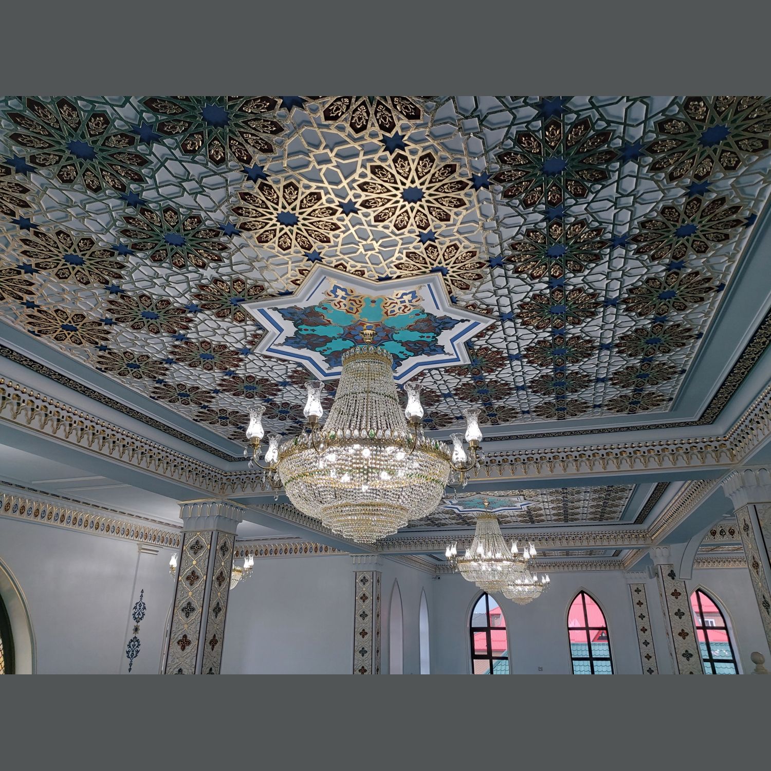 Orta boy kristal cami avizesinin işlemeli tavan altındaki görünümü
