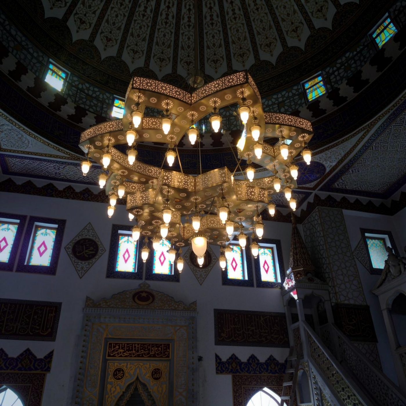 Yıldız formu lazer kesim cami avizesi kubbe altında asılı hâlde