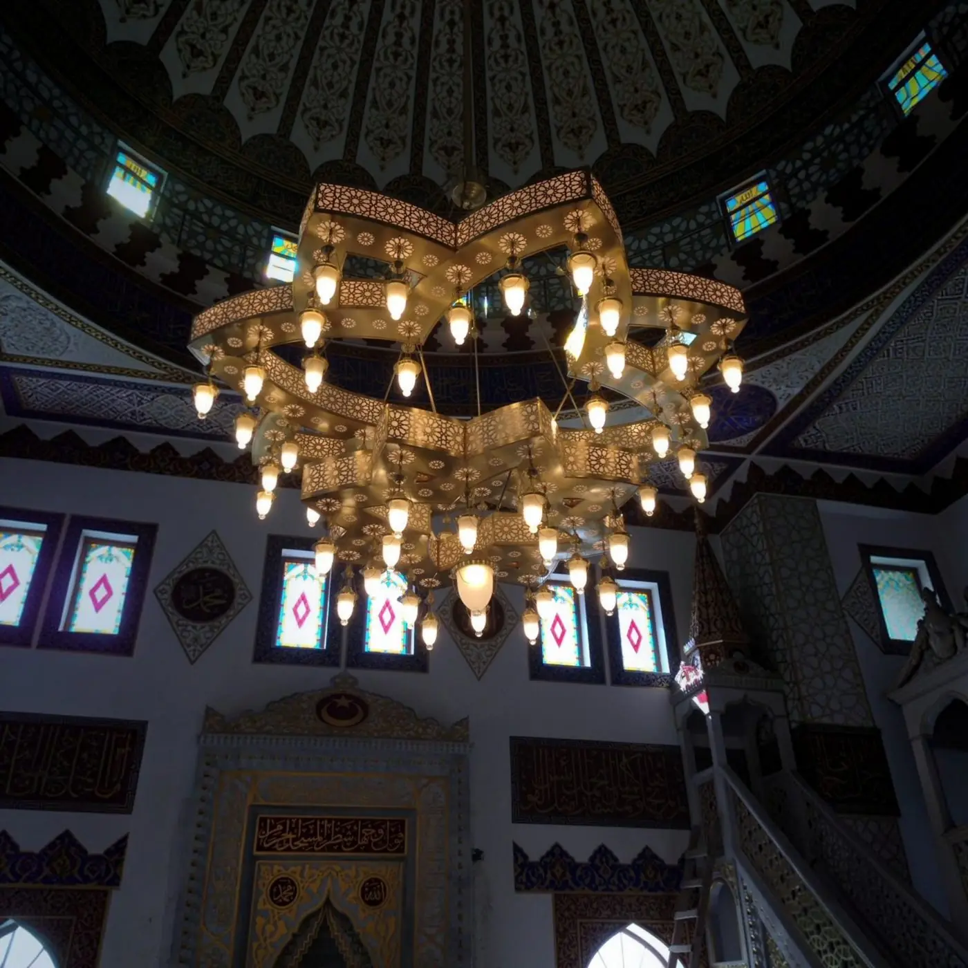 Yıldız formu lazer kesim cami avizesi kubbe altında asılı hâlde