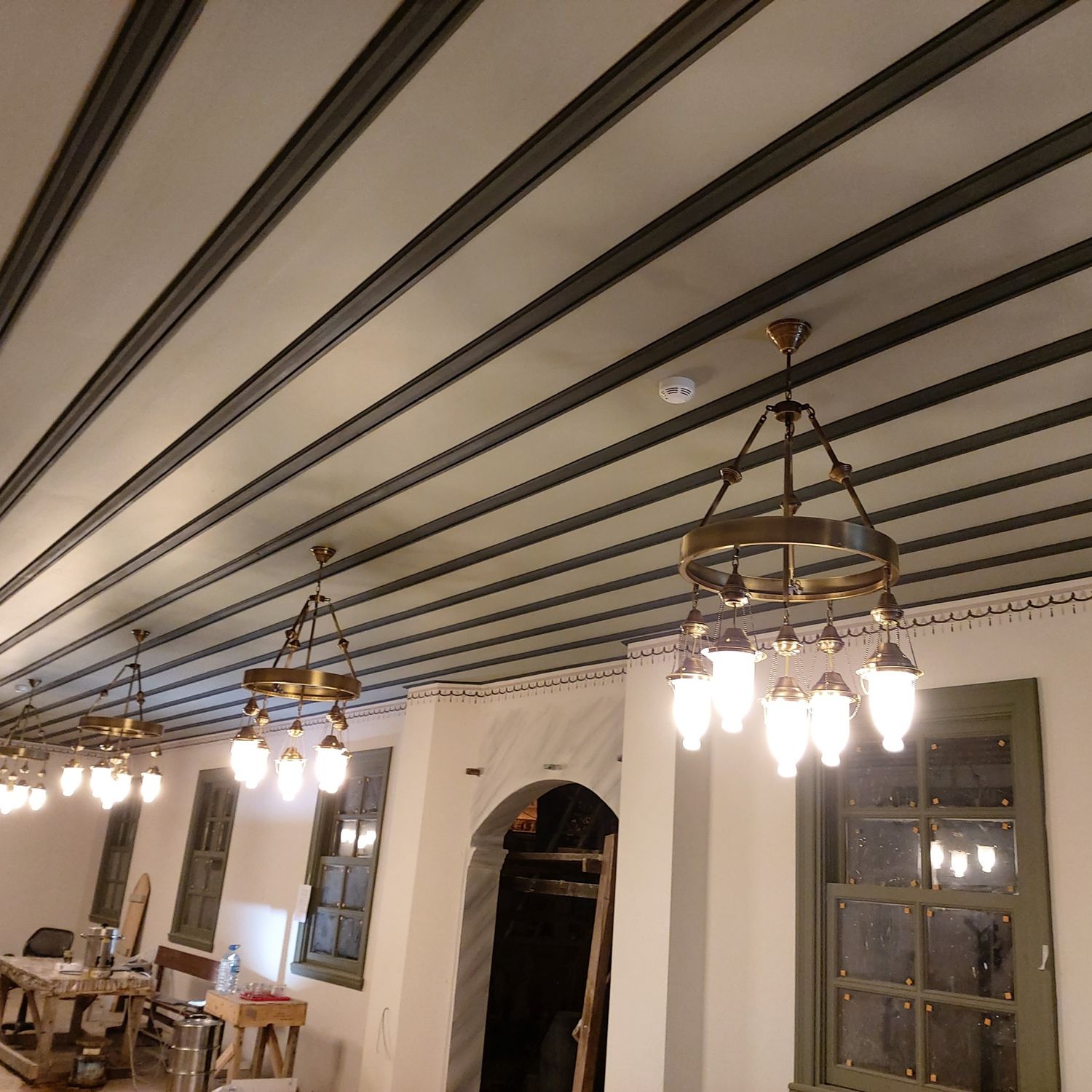 Zincirli fanuslu Osmanlı cami avizesinin salon boyunca sıra hâlinde dizilmiş uygulaması