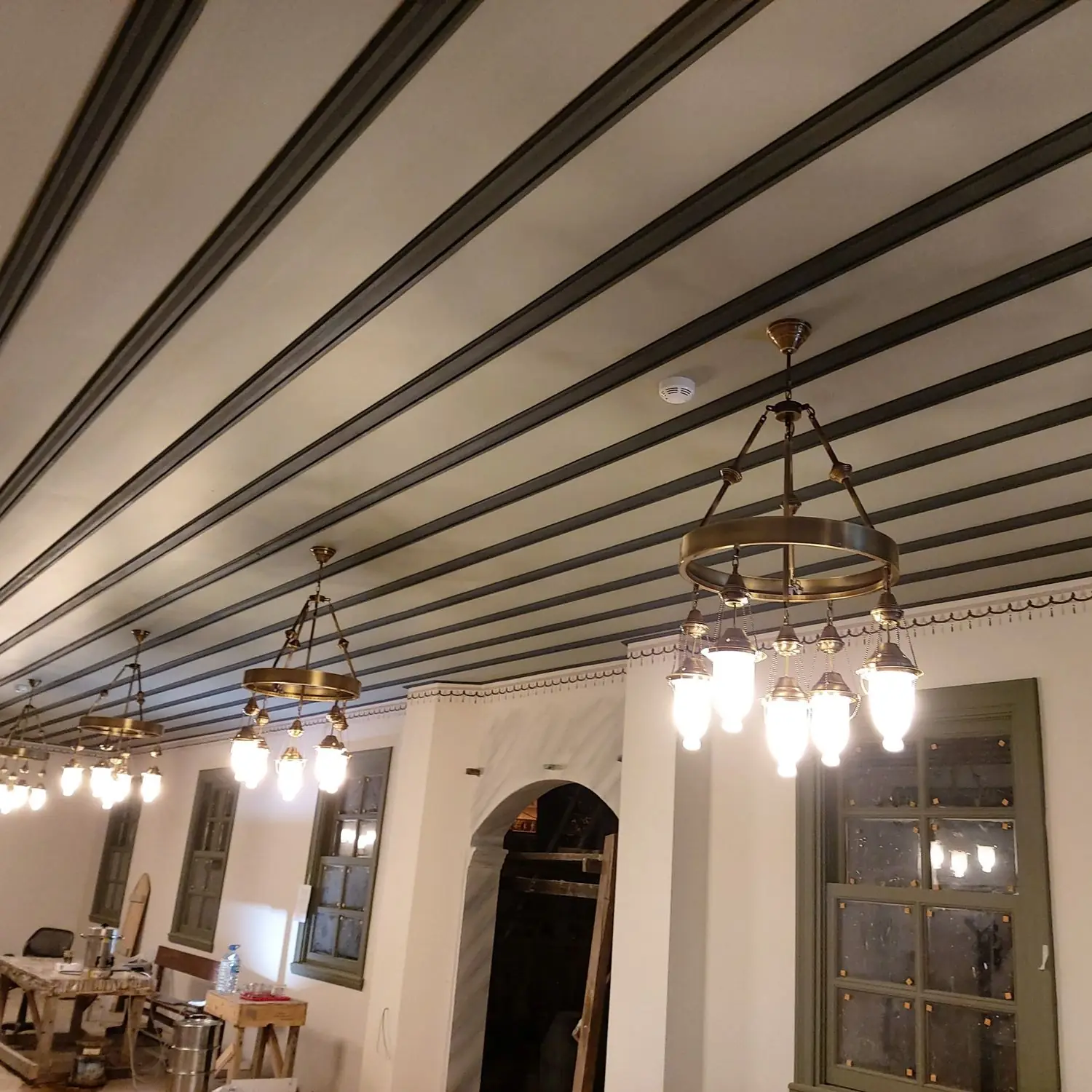 Zincirli fanuslu Osmanlı cami avizesinin salon boyunca sıra hâlinde dizilmiş uygulaması